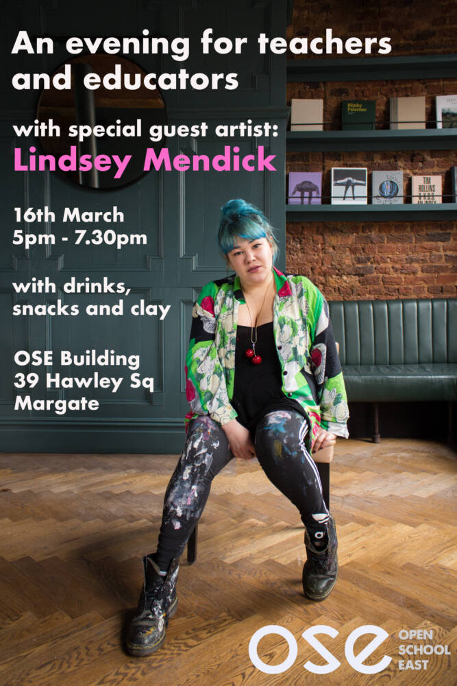 [ An artist with blue hair, colourful print shirt and leggings with paint on them, sits on a chair in a room with a wooden floor. Text is there as information for the event]